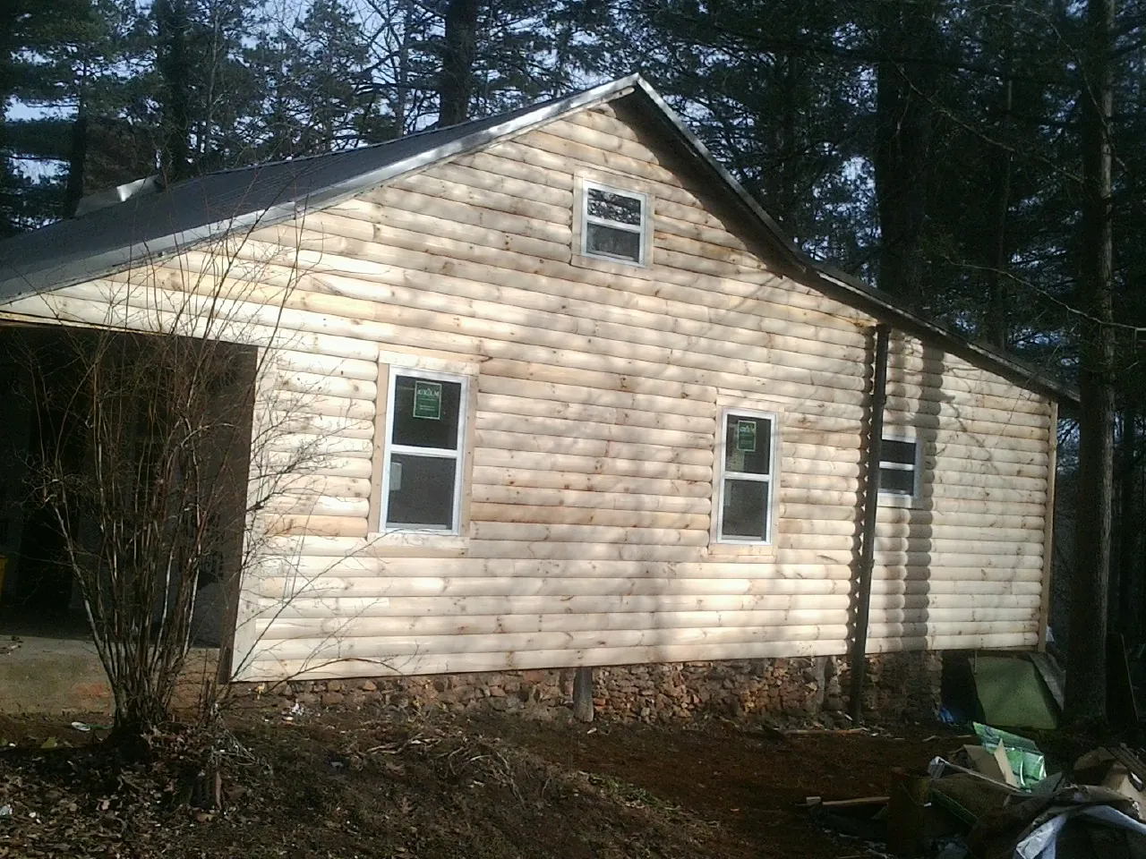 New log siding and dark metal roofing on a gable end in Sayreville