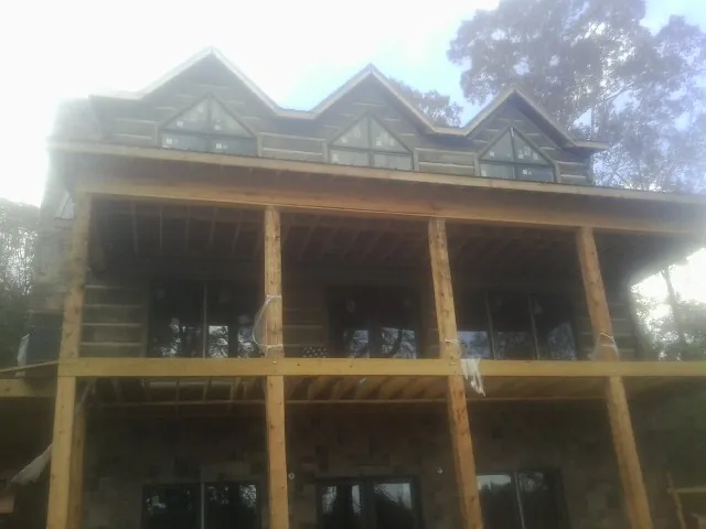 Dormers and porch framing on a large log home under construction — Roof Coating work by our crew in Sayreville