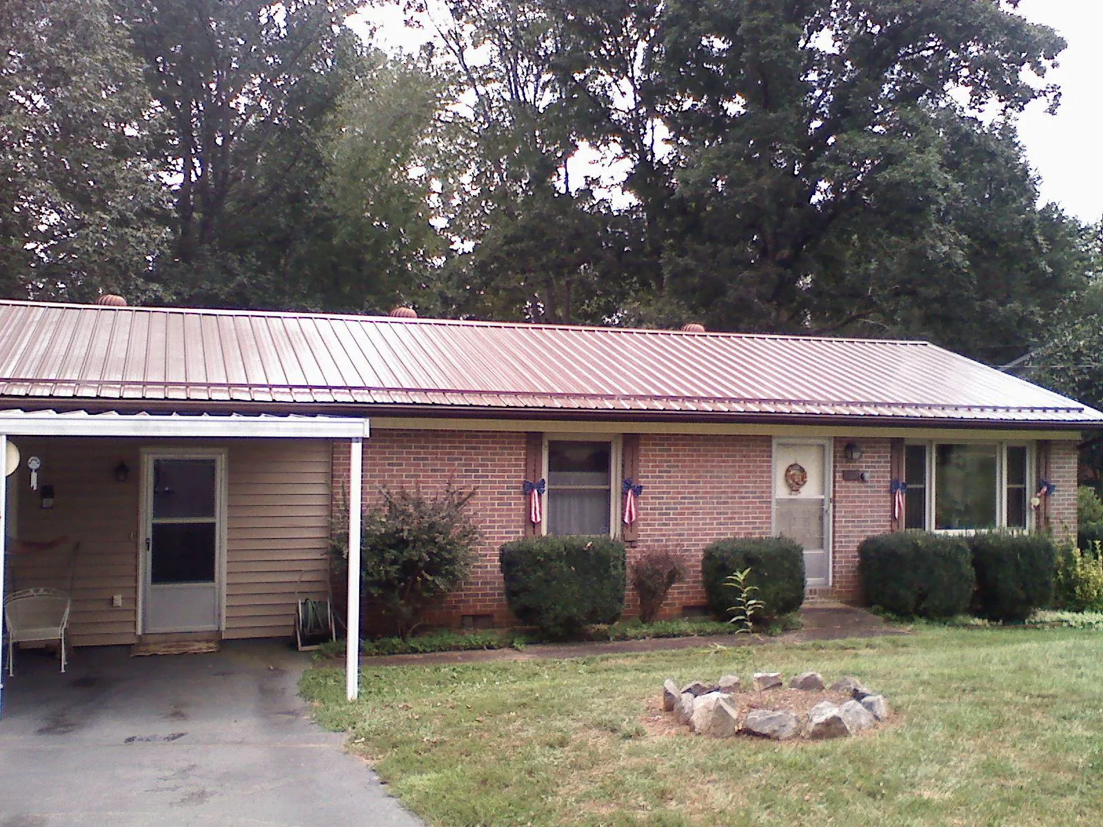 Bronze metal roof and carport on a brick ranch home — Roof Repair work by our crew in Sayreville